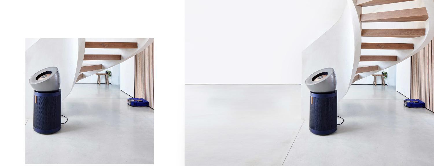 A modern home with a sweeping staircase and the Dyson robot vacuum and the Dyson Big+Quiet purifier.