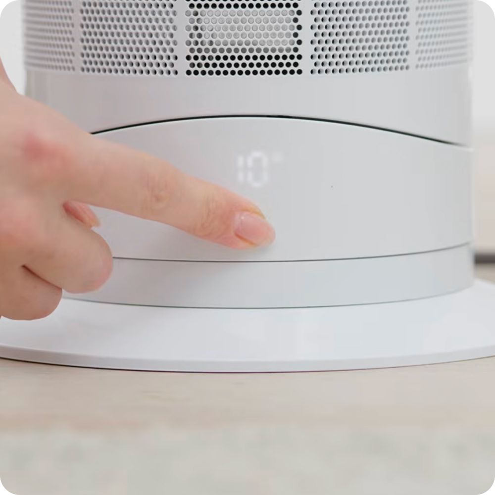 Power and control button pressed on a Dyson Hot+Cool AM09 fan heater.