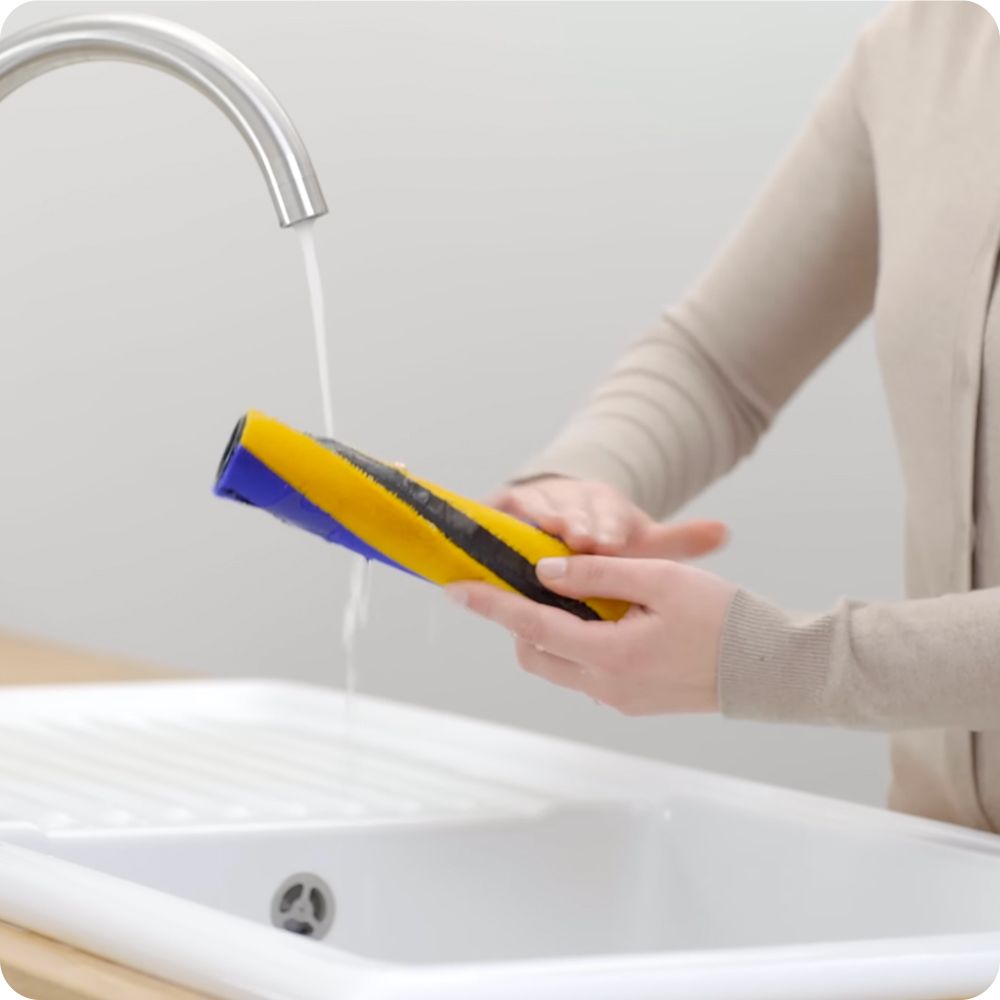 The brush bar of the Fluffy cleaner head is cleaned under running water.