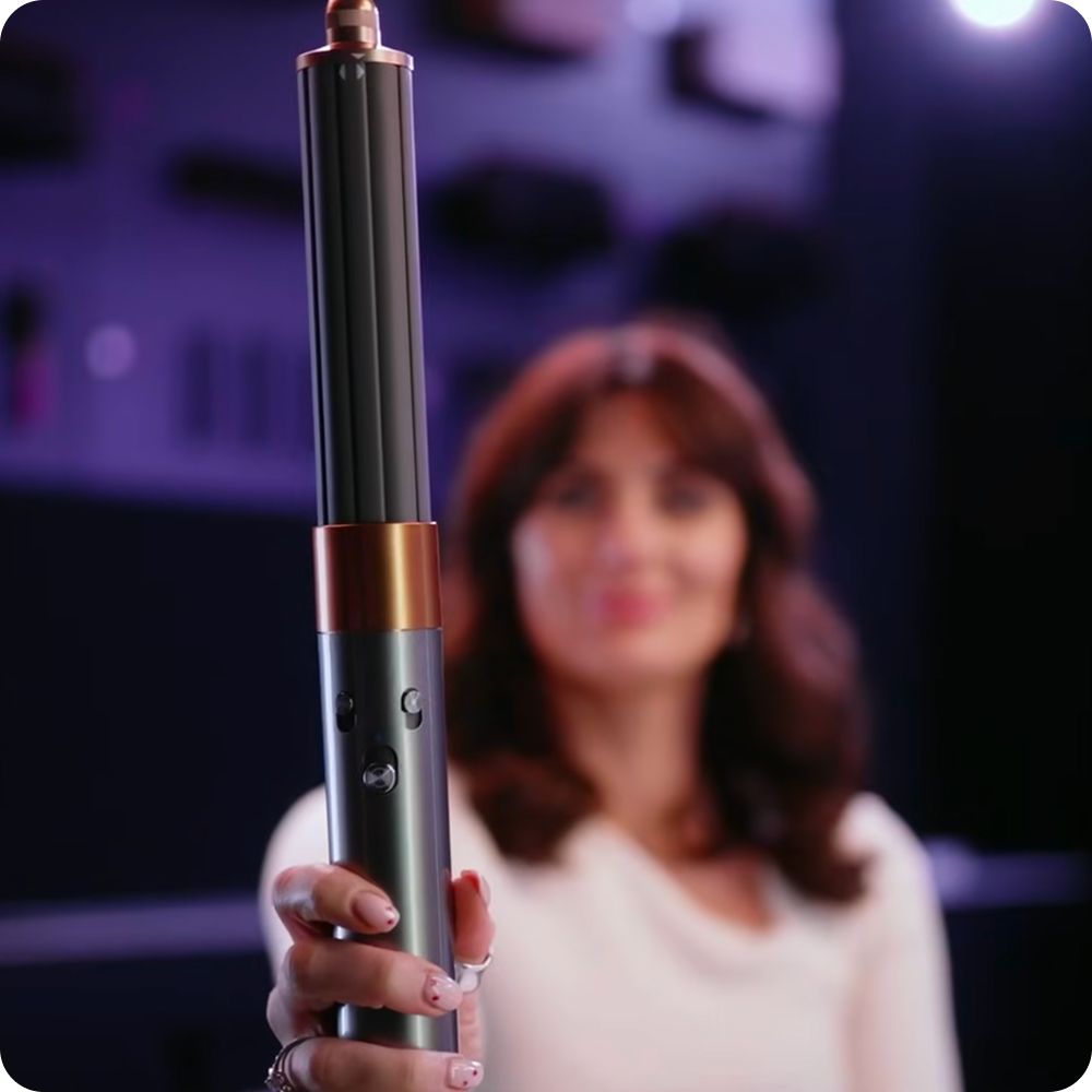 Dyson Airwrap multi-styler held in a hand.