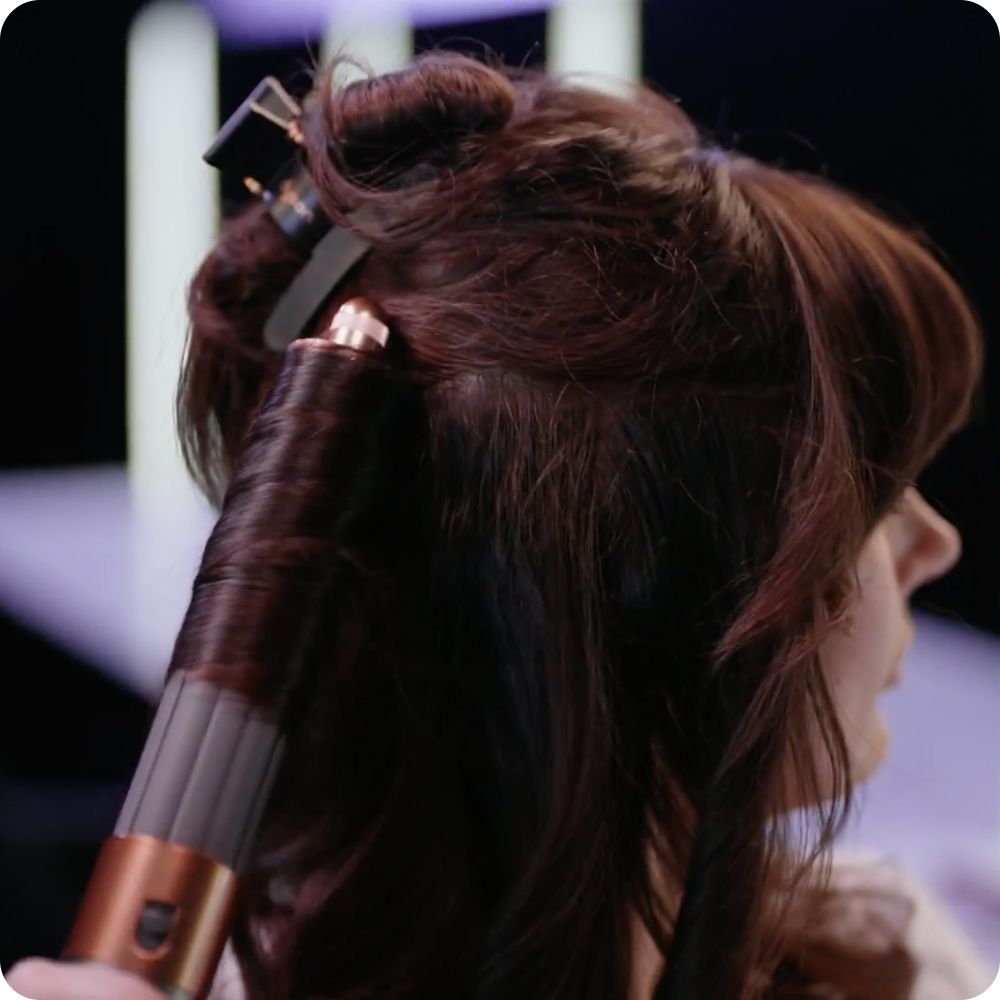 Hair is styled using a Dyson Hair care device.