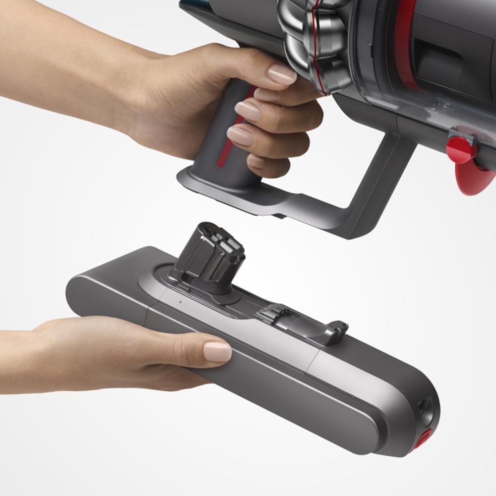A Dyson battery being clicked into the bottom of a cordless vacuum.