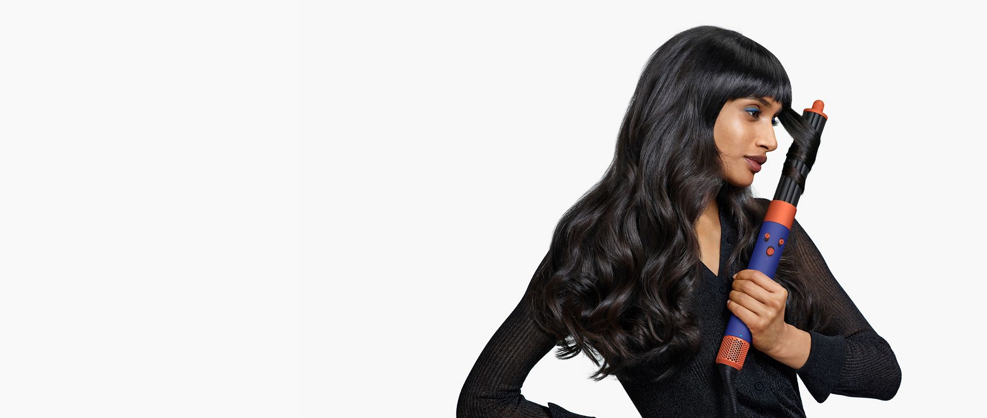 A model is curling her hair with an Airwrap ID multi-styler and dryer.