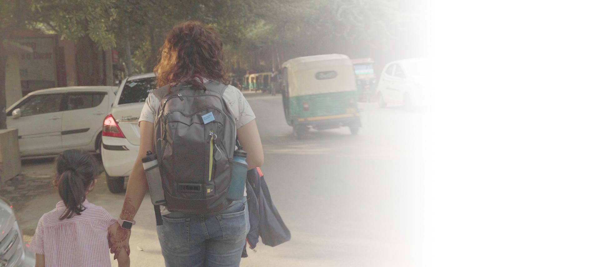 Mon with her daughter walking on street in pollution