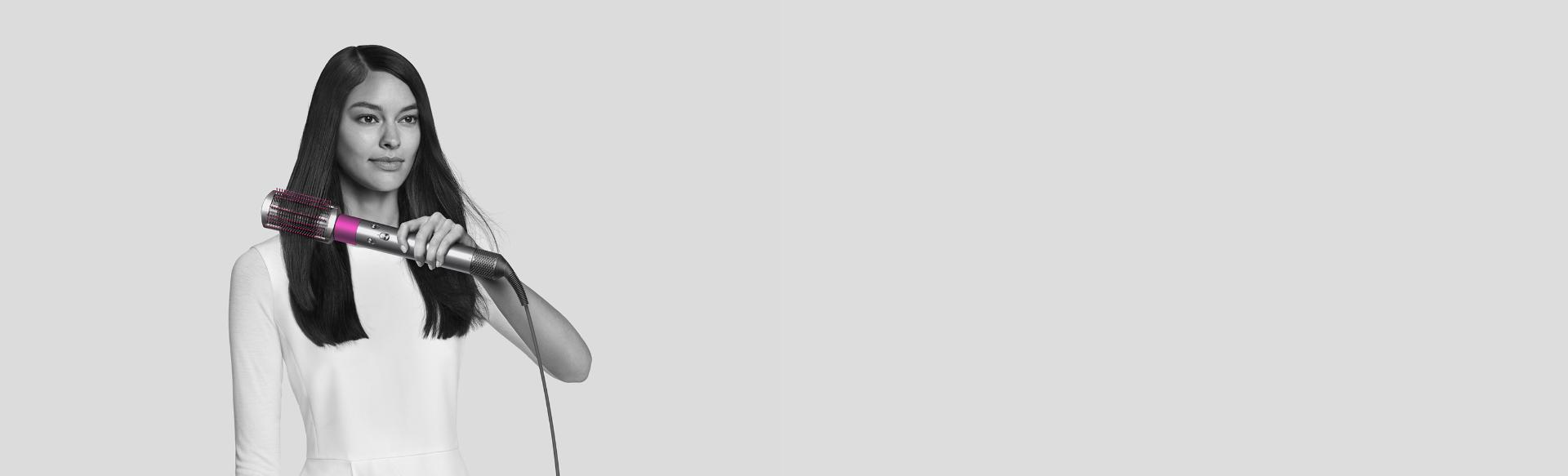 Woman curling hair with Dyson Airwrap styler.
