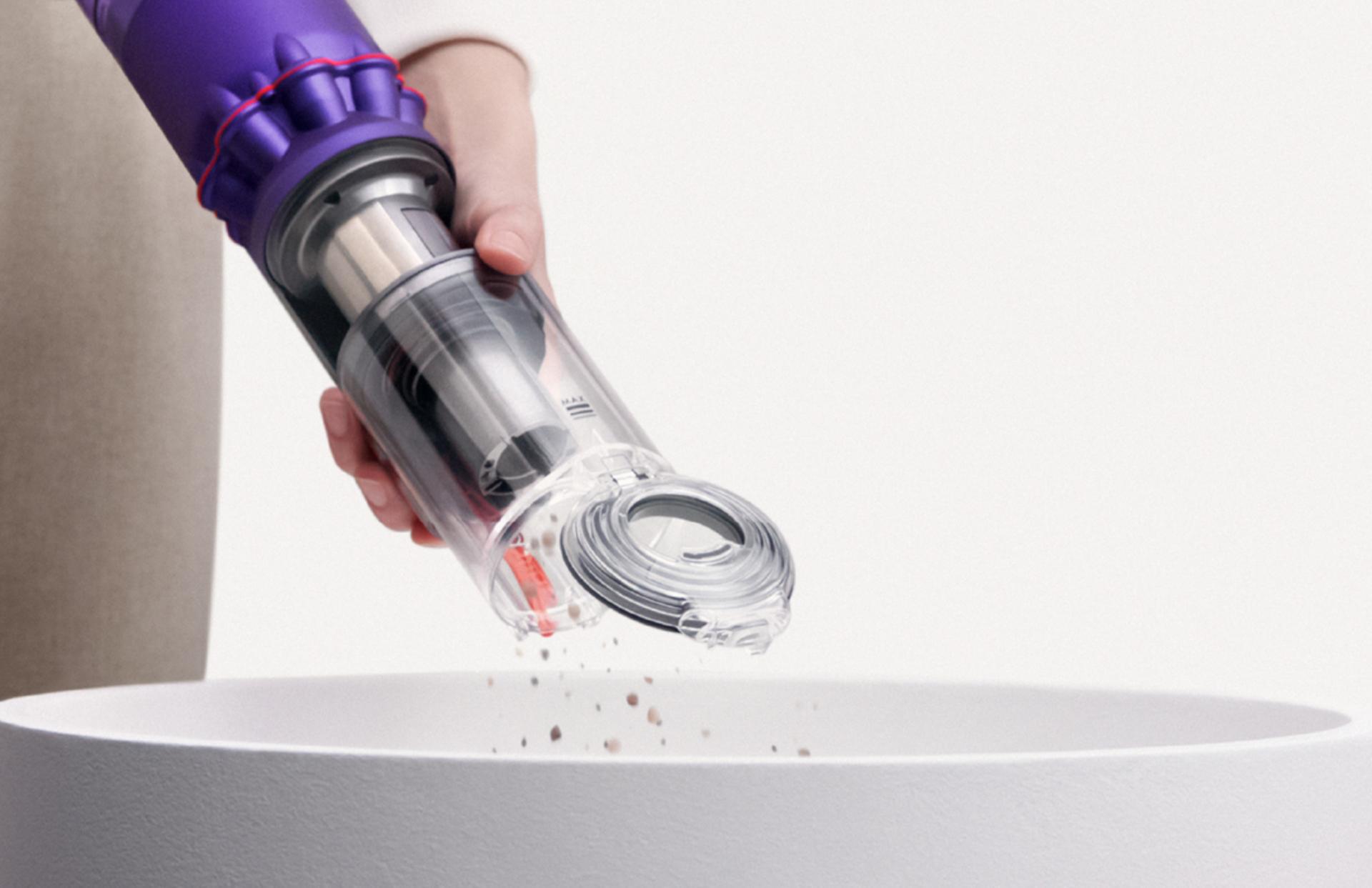 Woman washing vacuum parts under a tap.