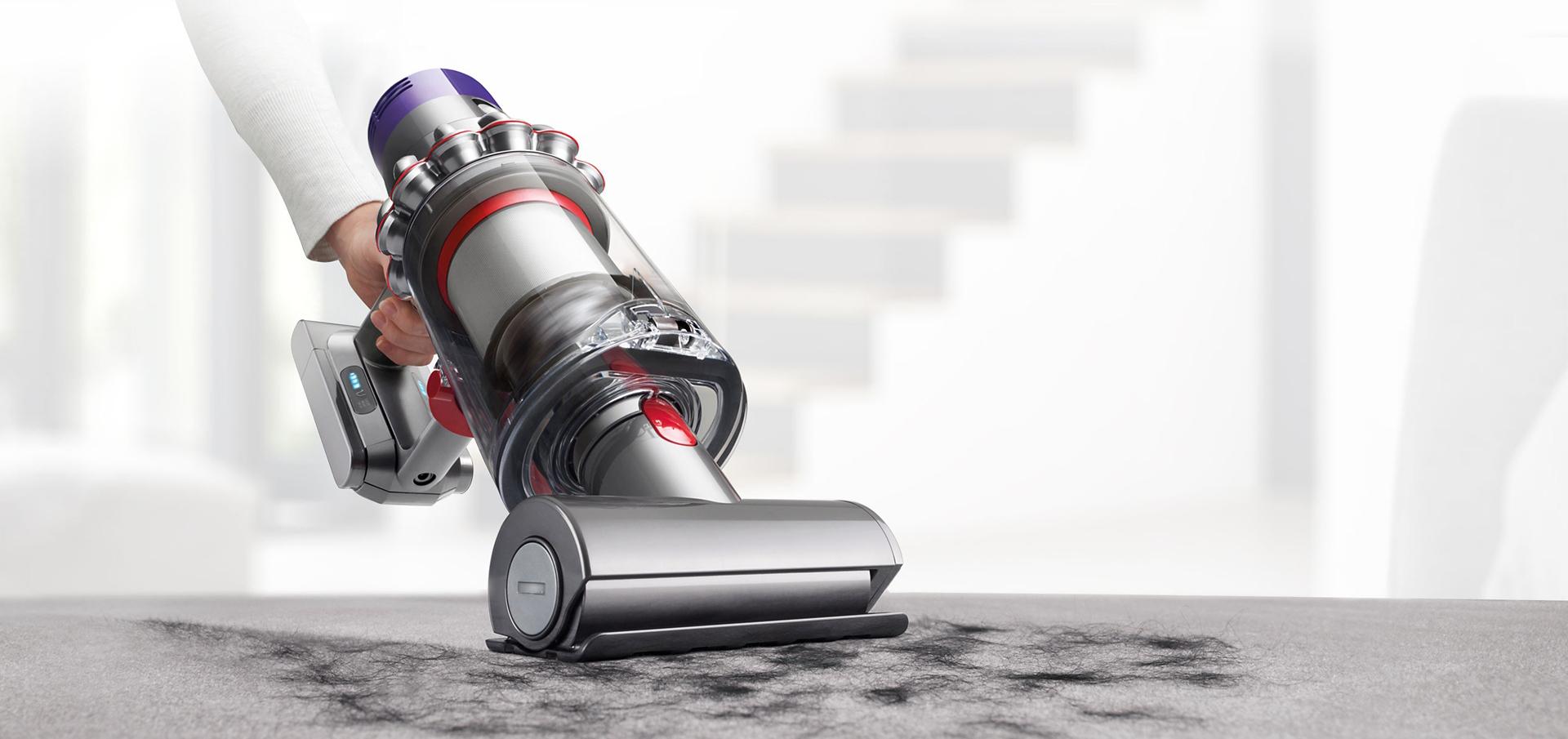 Dyson Cyclone V10™ vacuum in handheld mode cleaning upholstery