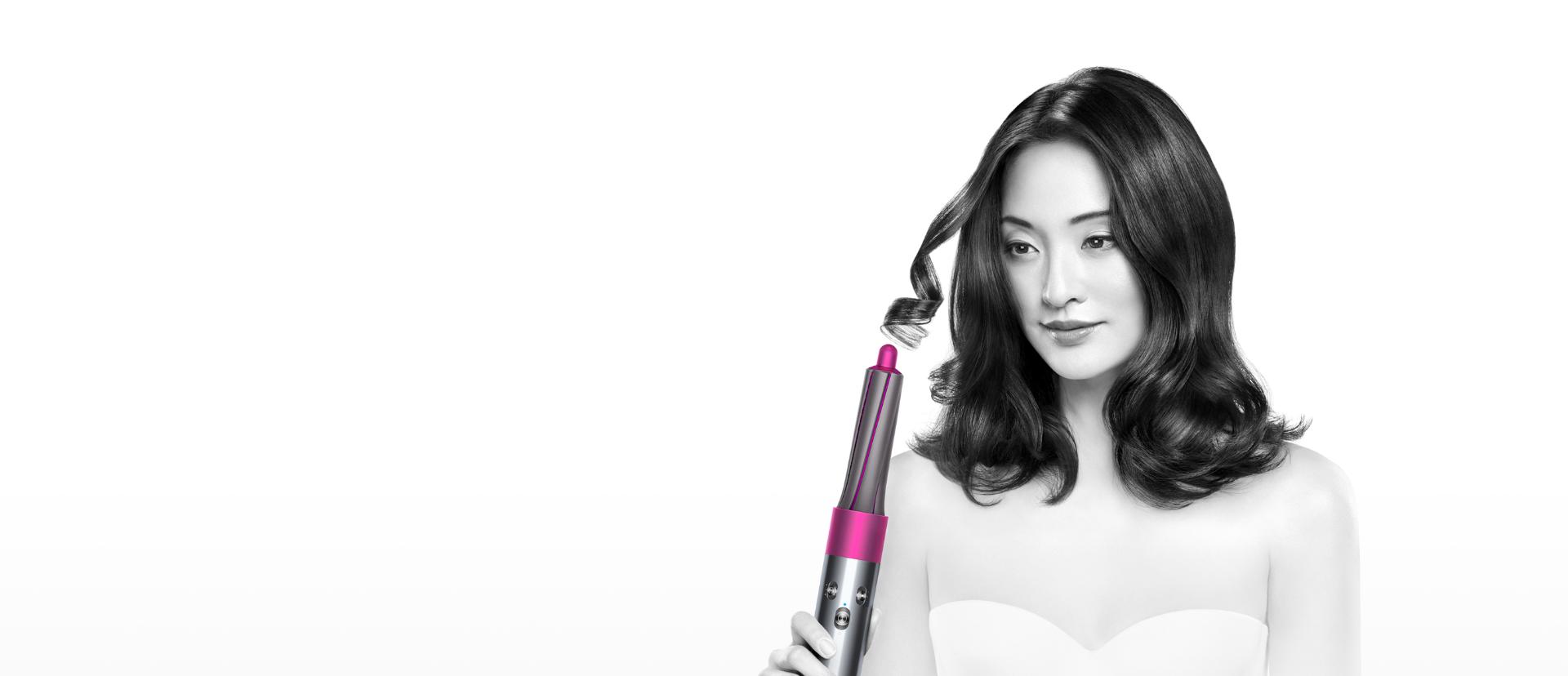 Model demonstrating the Dyson Airwrap™ hair styler to create bouncy curls