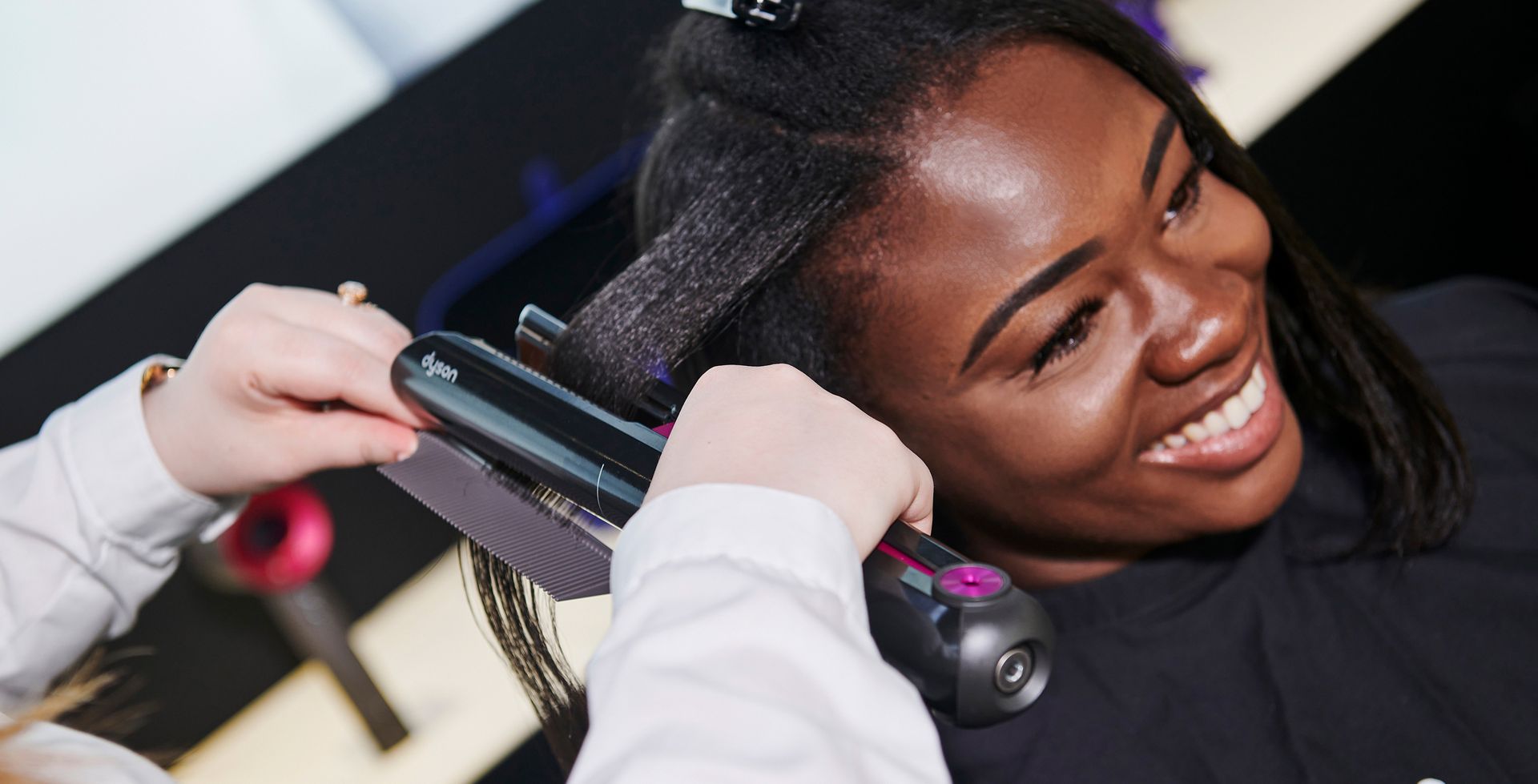 Dyson Stylist hilft einer Person mit einer Stylingvorführung
