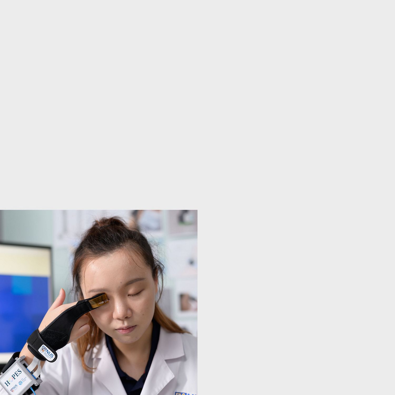 Mulher com os olhos fechados a testar os dados do glaucoma através de um dispositivo de retenção de dados bluetooth.