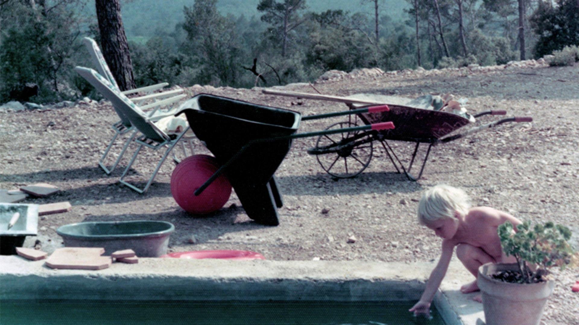 Jake Dyson puts his little hand into the small garden pool
