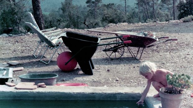 Jake Dyson puts his little hand into the small garden pool