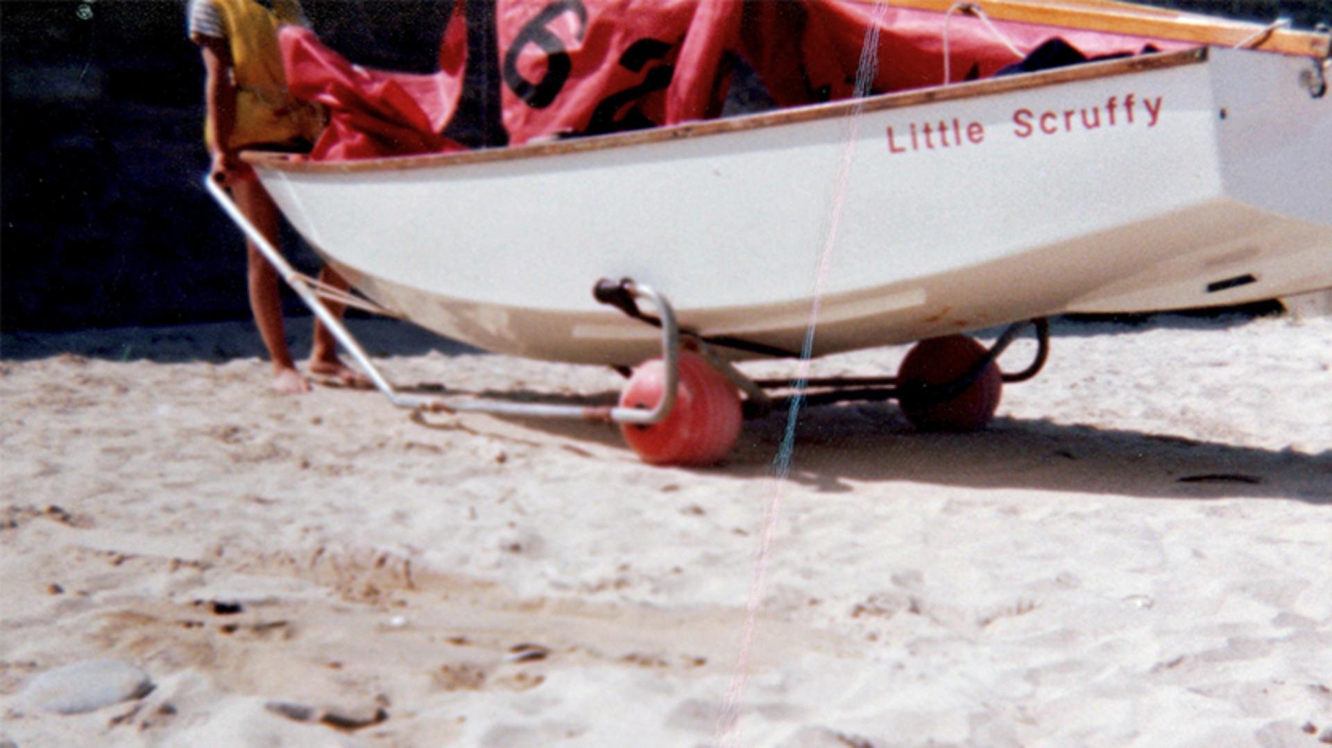 A side view of a small boat, sitting on a Trolleyball frame