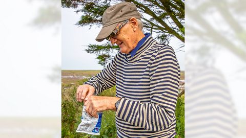 James Dyson holding a bag of Smiths potato crisps