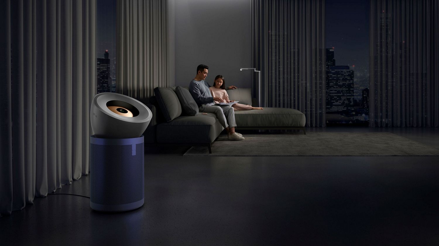 Dyson air purifier in a living room with a father and daughter relaxing on a sofa.