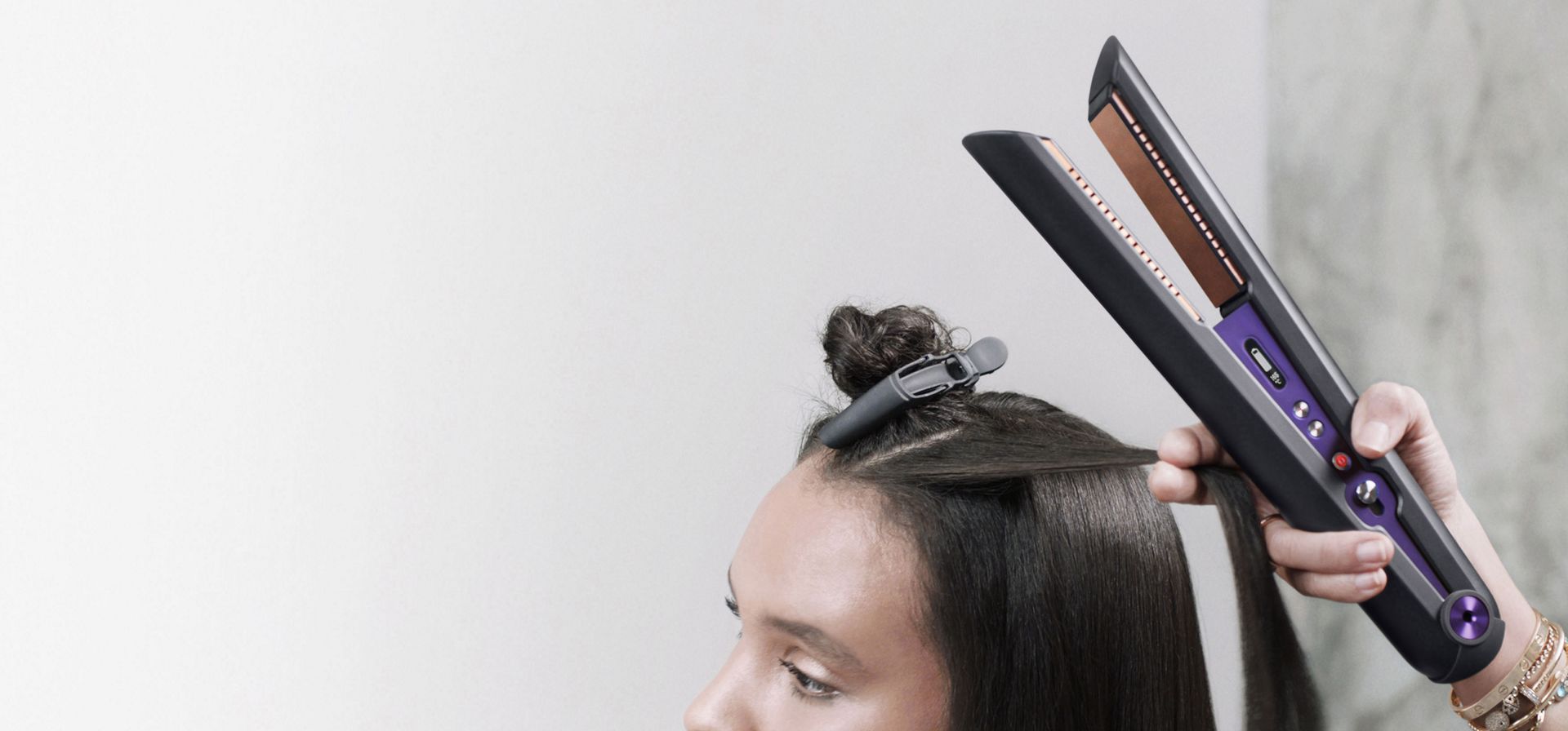  Primo piano di parrucchiere professionista che utilizza la piastra per capelli Dyson Corrale. Per stilisti e saloni