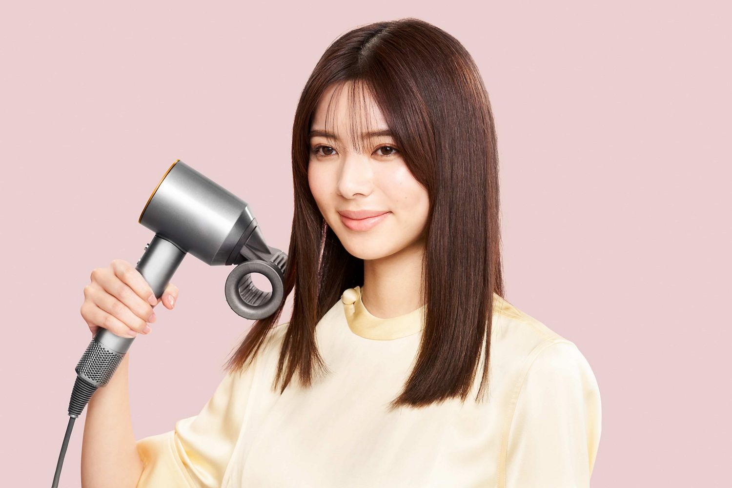 Dyson Supersonic Shineヘアドライヤーを持っている女性