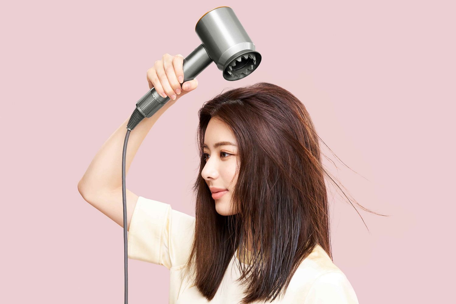 ドライヤーで髪を乾かしている女性