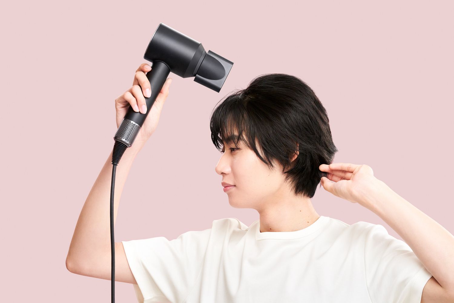 ドライヤーで髪を乾かしている女性