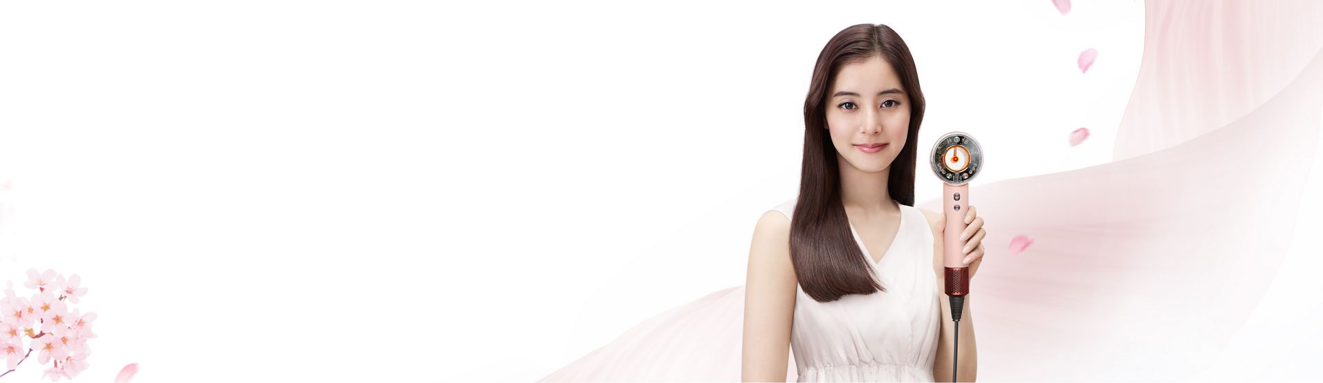 Dyson Supersonic Nural Shineヘアドライヤー さくらチェリーカラーを手に持つ女性