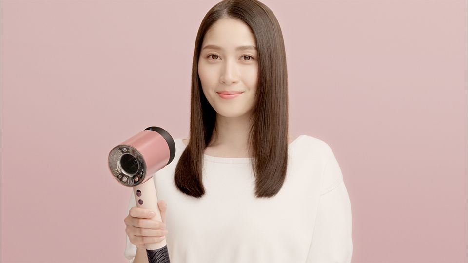 Dyson Supersonic Nural Shineヘアドライヤーを手に持つ女性モデル
