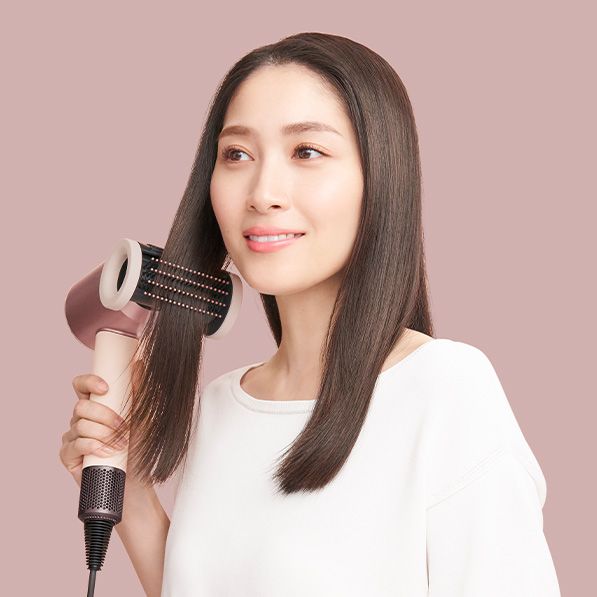 Dyson Supersonic Nural Shineヘアドライヤーを使用している女性