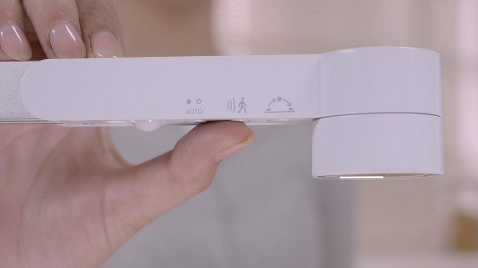 Uma pessoa a ajustar o candeeiro de trabalho Dyson Lightcycle™
