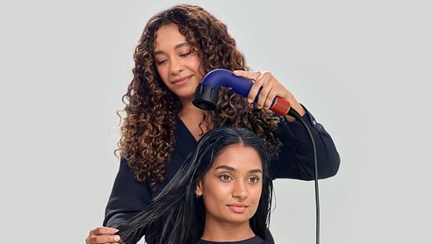 Dyson Global Styling ambassador drying models hair with the Dyson Supersonic r hair dryer with the Diffuser attachment.