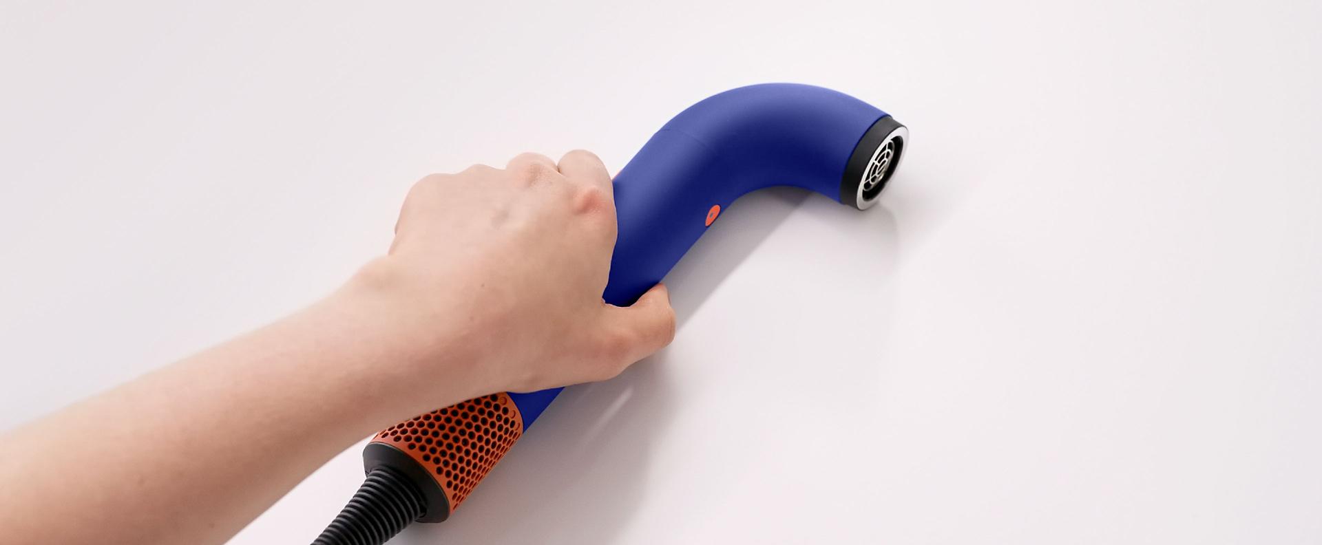 Hand picking up the Dyson Supersonic r Professional hair dryer.