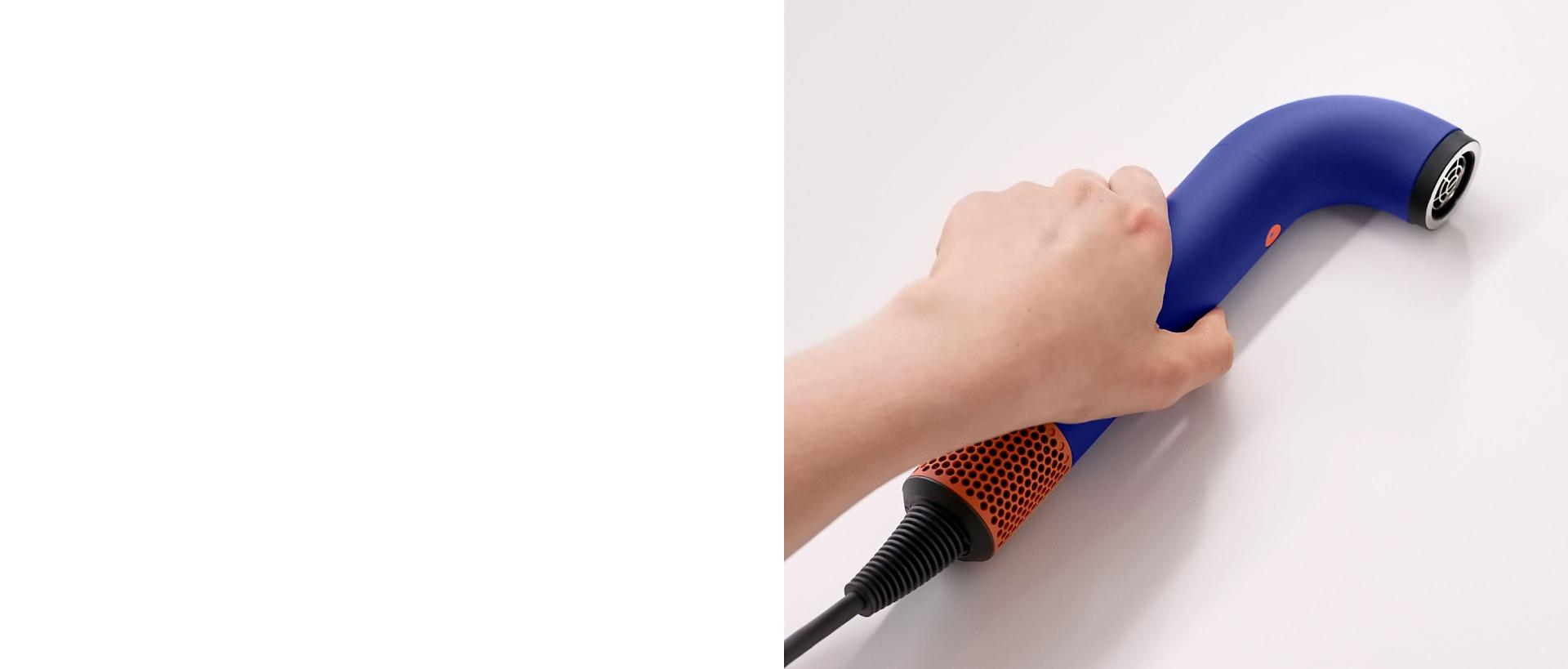 Hand picking up the Dyson Supersonic r hair dryer.