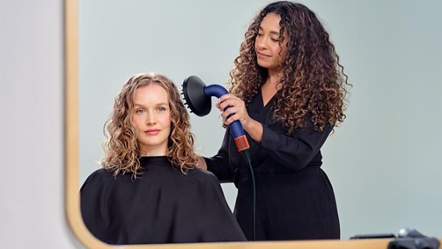 Dyson Global Styling ambassador drying models hair with the Dyson Supersonic r hair dryer with the Diffuser attachment.