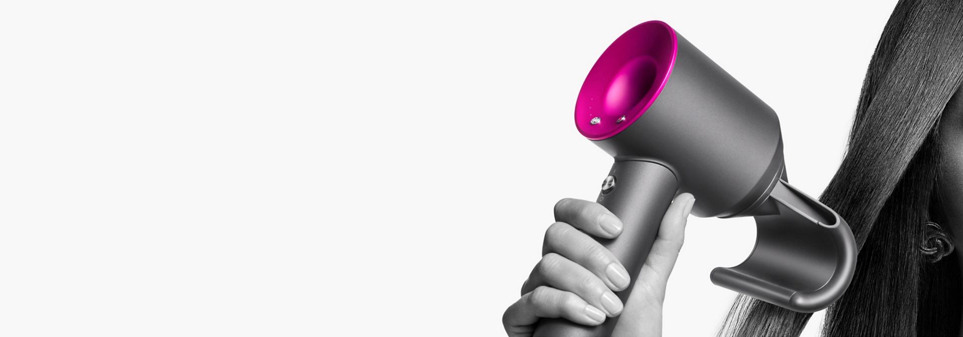 Elektriklenmeyi önleyen Flyaway başlık ile Dyson Supersonic saç kurutma makinesini tutan bir model.