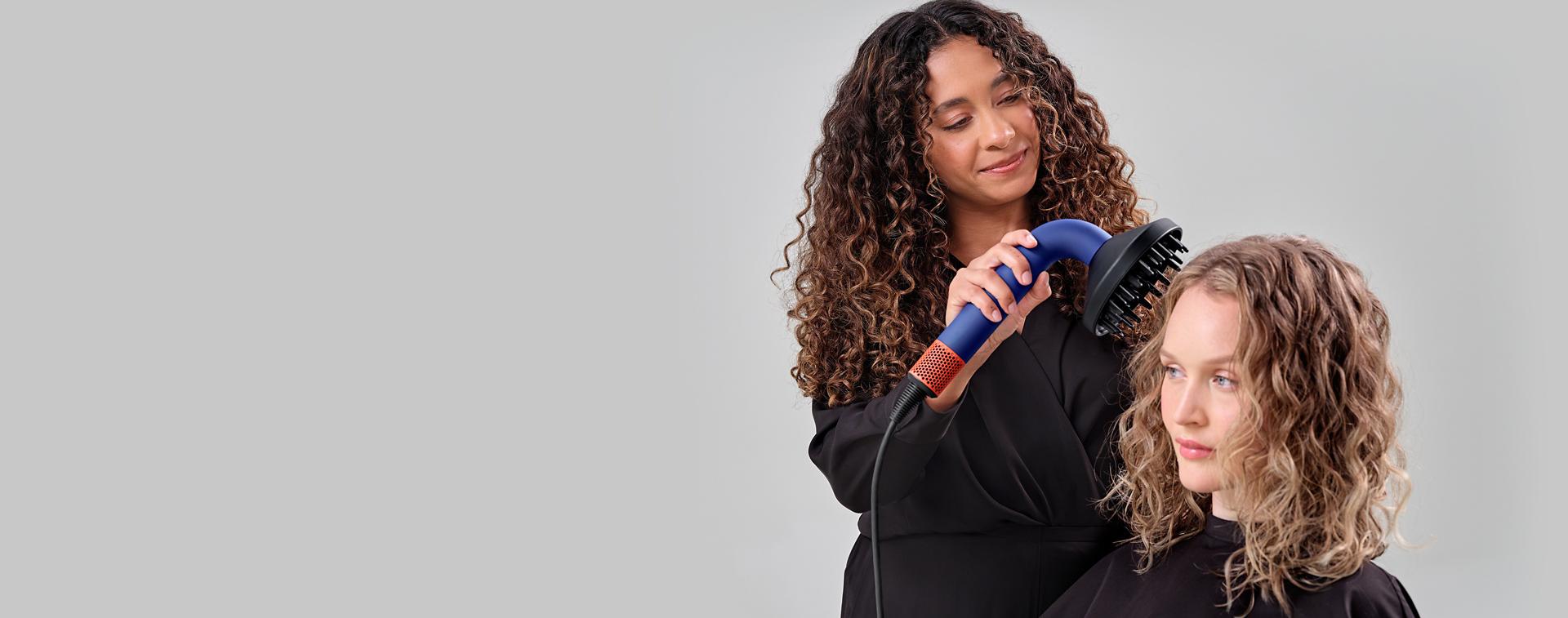 Dyson Supersonic r Professional hair dryer is used on a model to dry hair.