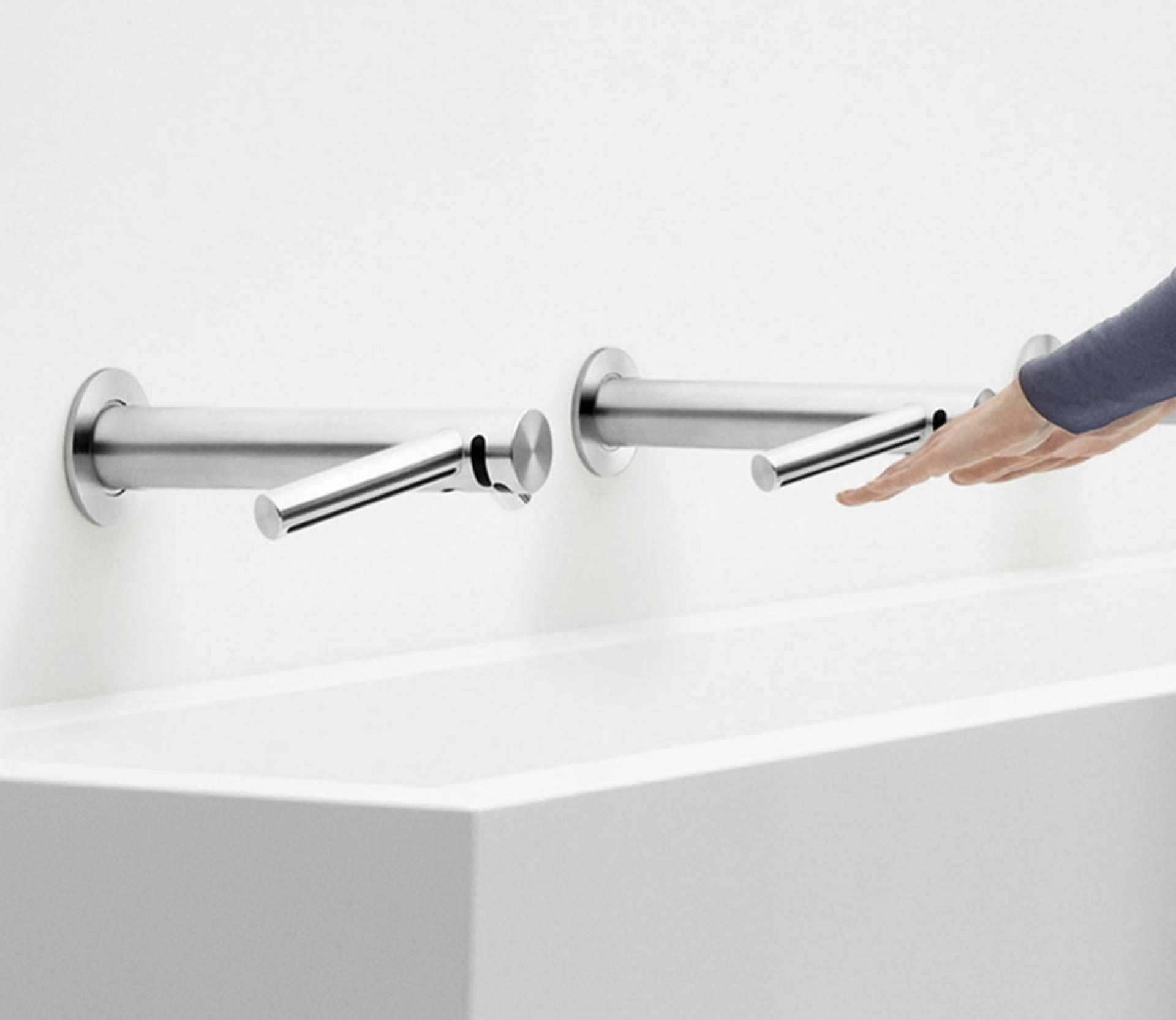 A pair of hands being dried by a Dyson Airblade Wash+Dry that has been installed over a sink.