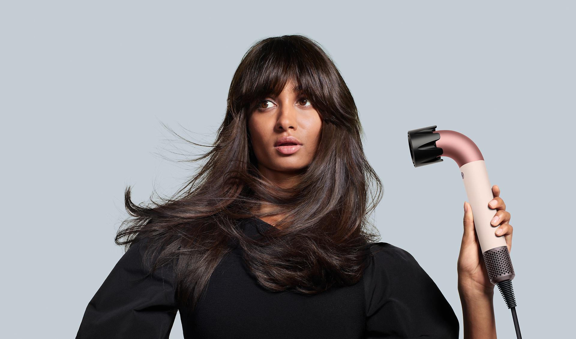 The Dyson Supersonic r hair dryer with the Powerful air attachment is used by a model to rough-dry her hair