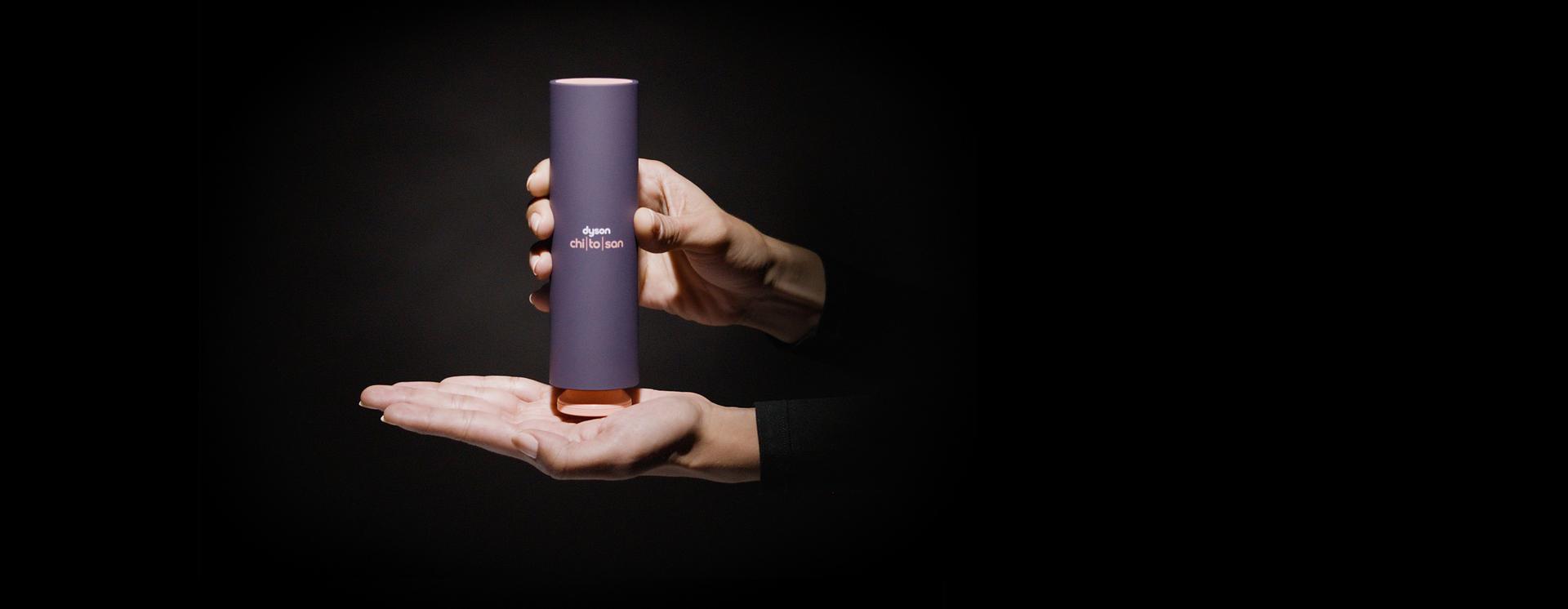 يد تحمل زجاجة من Dyson Chitosan، ووضعية المضخة في وسط كف اليد