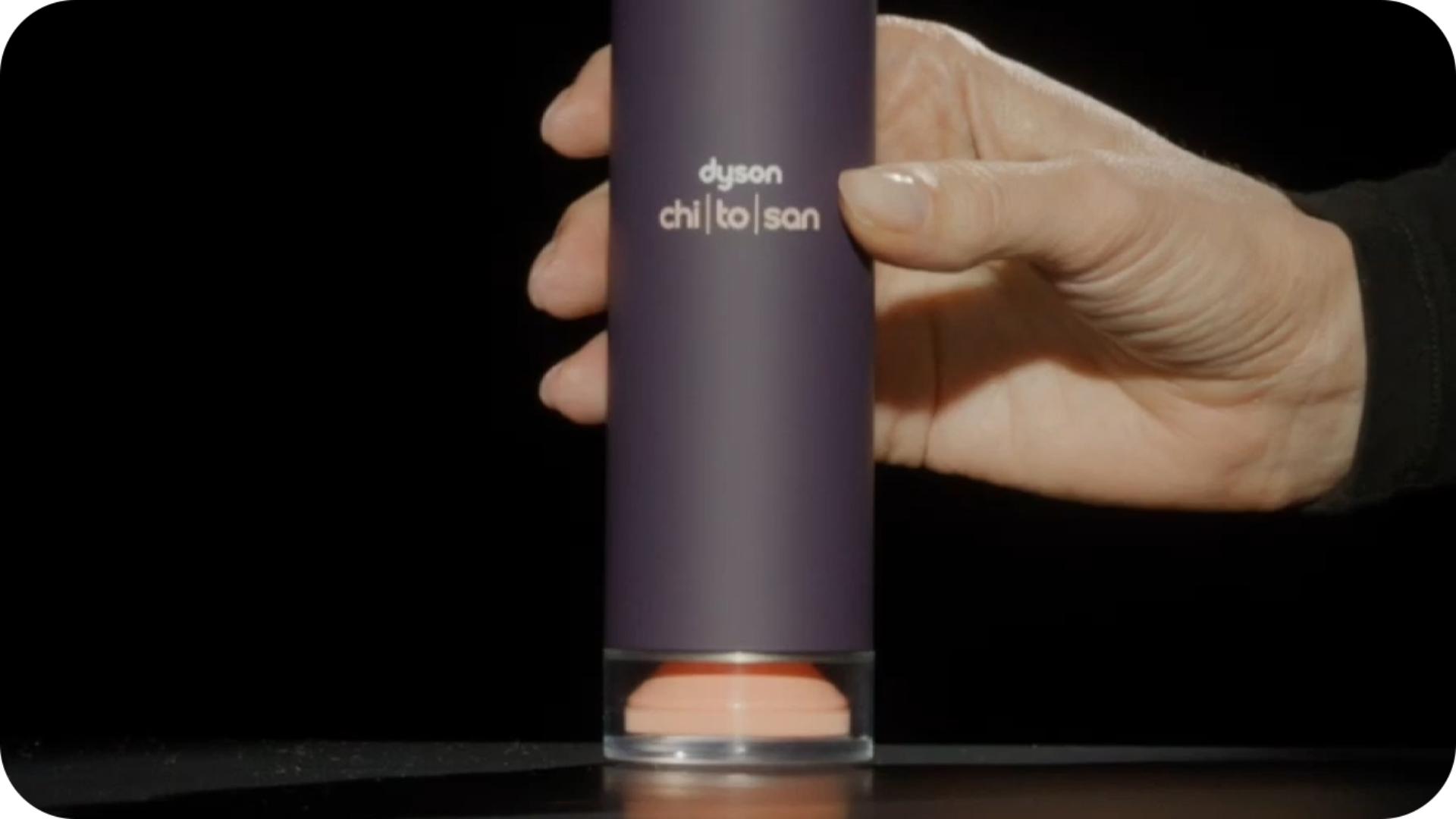 Dyson Chitosan pompalı şişeyi gösteren bir model eli