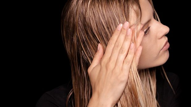 Model applying Pre-style cream to damp hair