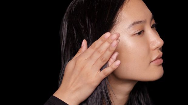 عارِضة تضع كريم ما قبل التصفيف على شعر رطب