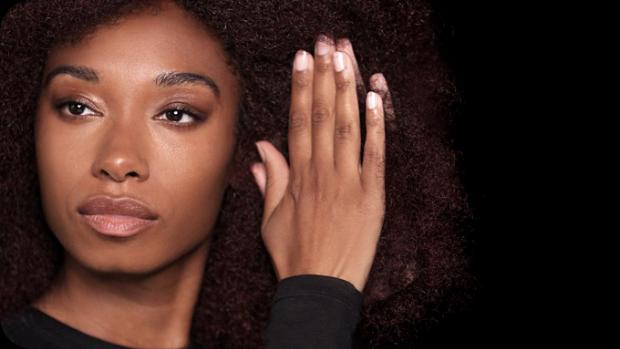 Model applying Pre-style cream to damp hair