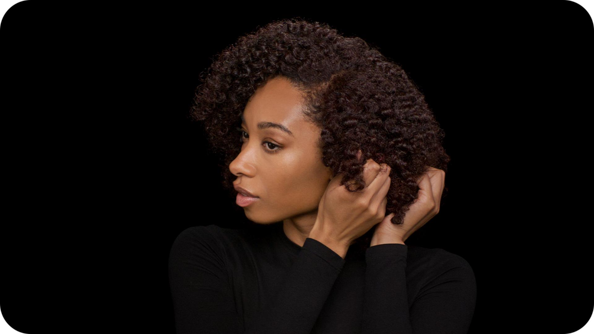 عارِضة تُطبّق سيروم ما بعد التصفيف على تسريحتها النهائية