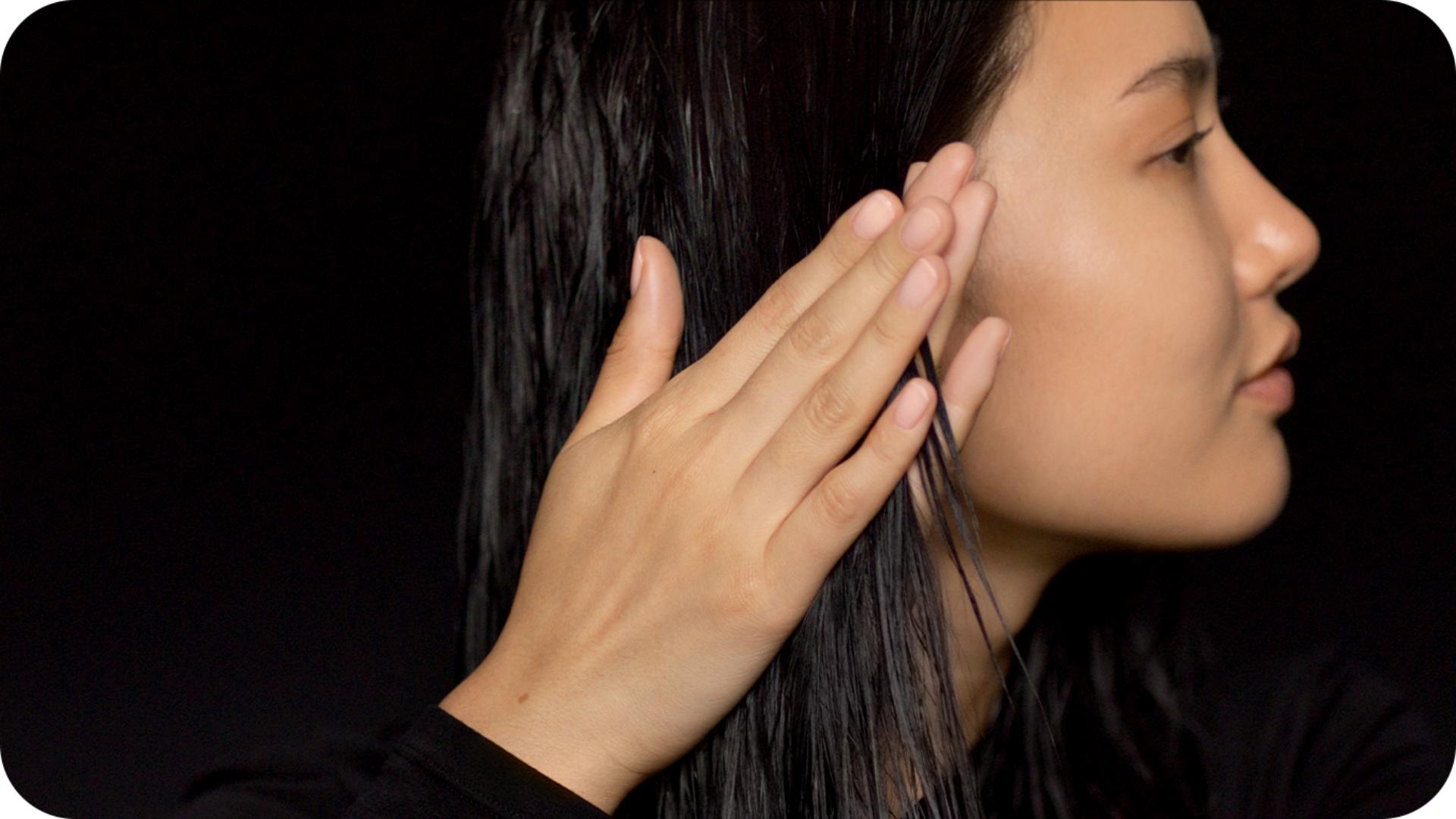 Model applies Pre-style cream to towel-dried hair
