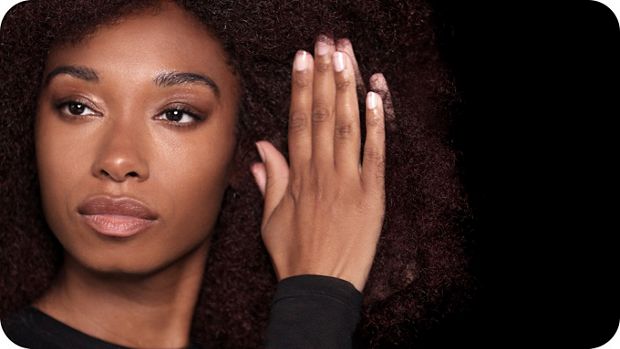 Modelka nakłada krem na osuszone ręcznikiem włosy.