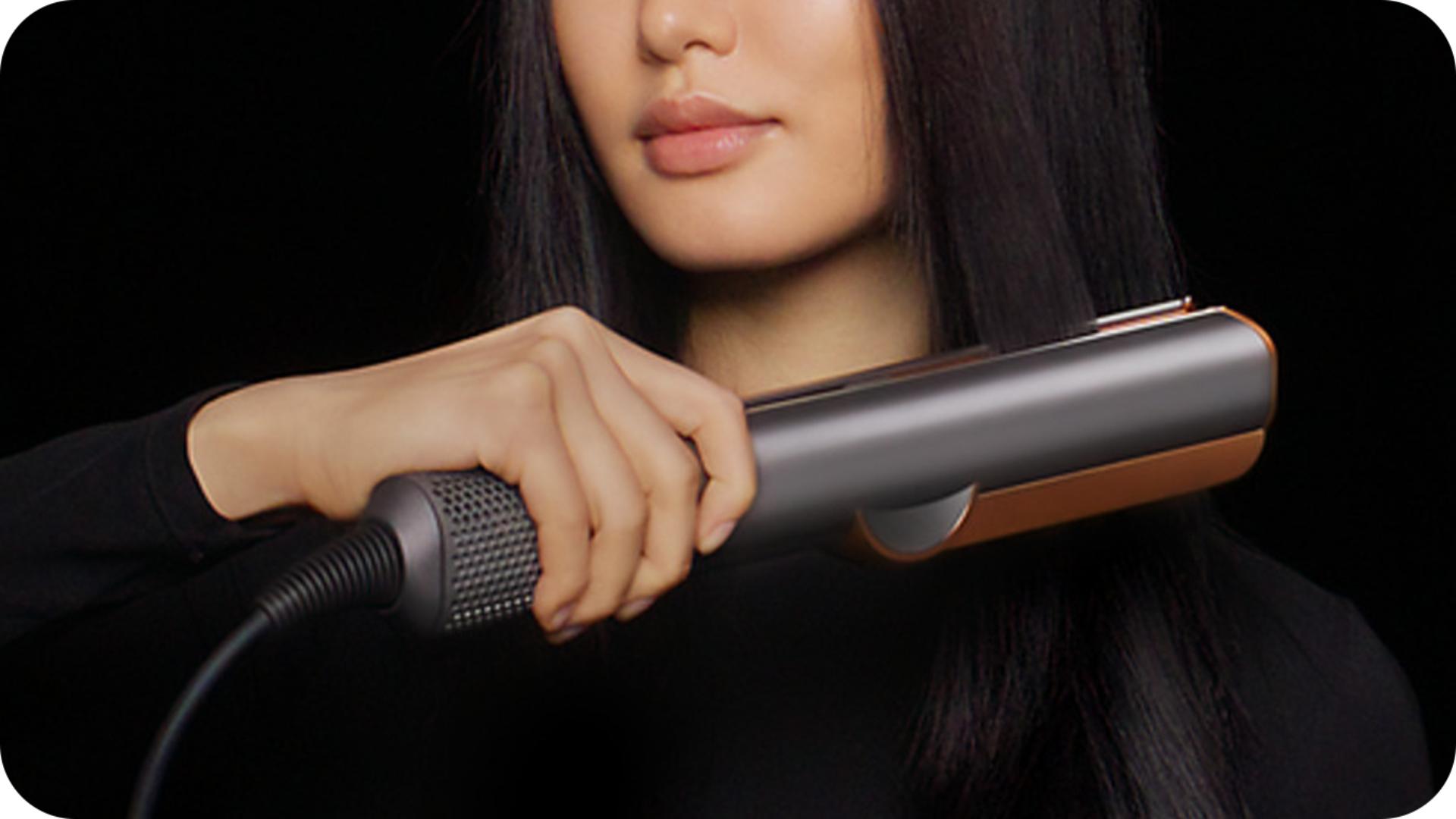 Model uses Dyson Airstrait wet to dry straightener to dry and style hair
