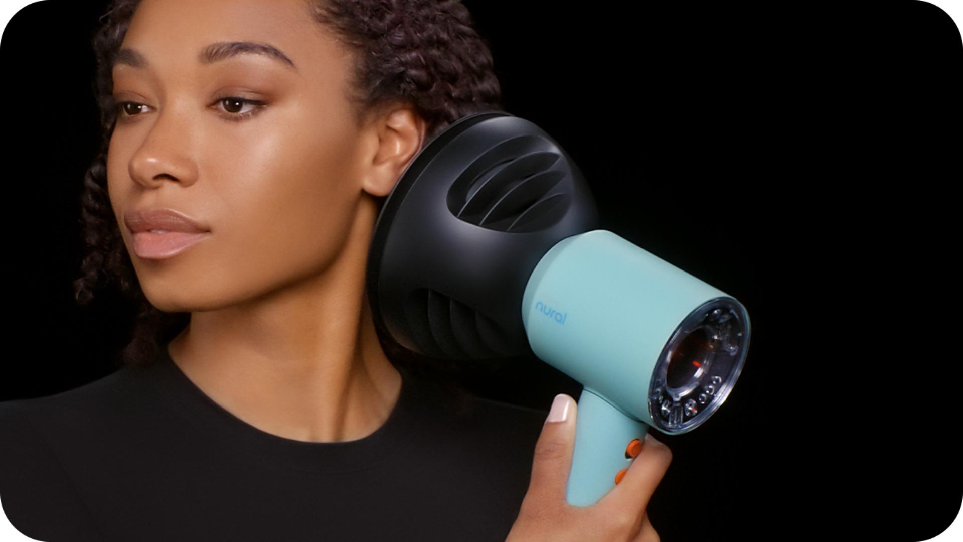 عارِضة تَستخدم مجفف الشعر Dyson Supersonic لتجفيف شعرها وتصفيفه