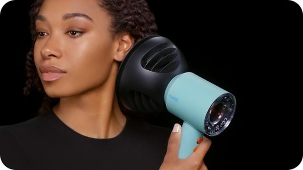 Modelka używa suszarki do włosów Dyson Supersonic do suszenia i stylizacji włosów