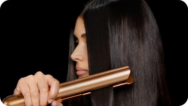 Model uses Dyson Airstrait wet to dry straightener to dry and style hair
