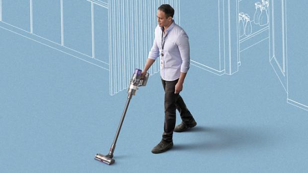 Man using Dyson cordless vacuum to clean floors