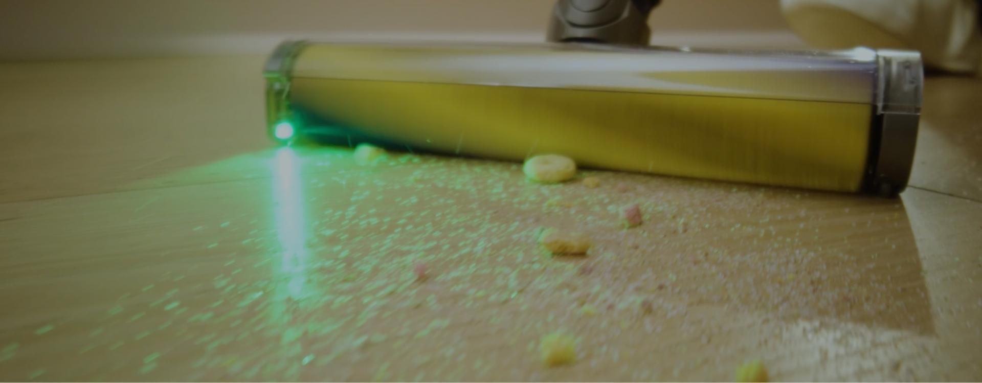 Fluffy optiskā putekļu sūcēja uzgalis atklāj grūti ieraugāmus putekļus uz cietā grīdas seguma.