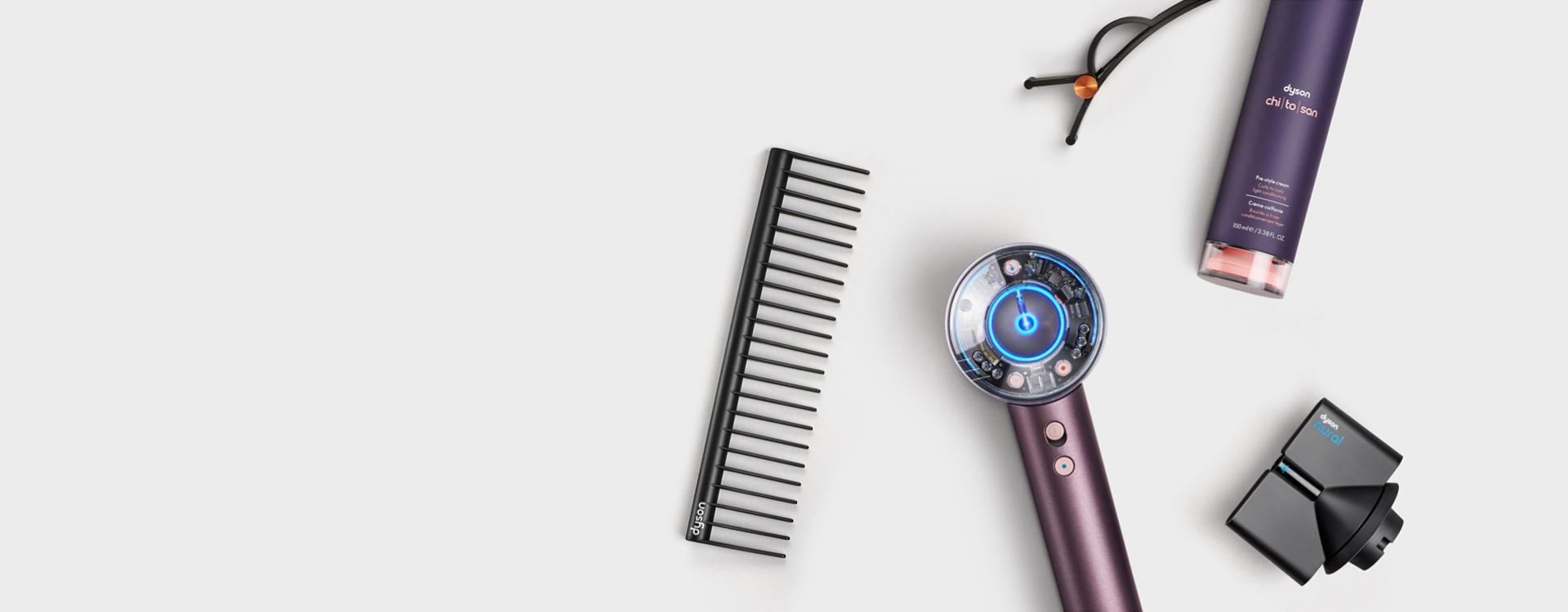 The Dyson Supersonic Nural hair dryer in Jasper plum surrounded by attachments and accessories.